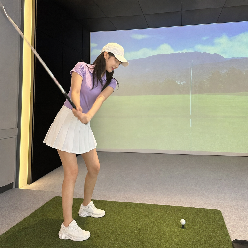 ダウンスイングで左肩を低く保つ若い女性ゴルファー、屋内ゴルフシミュレーター